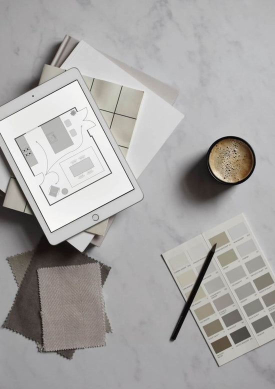 iPad displaying design software, coffee cup, and color swatches on a marble surface