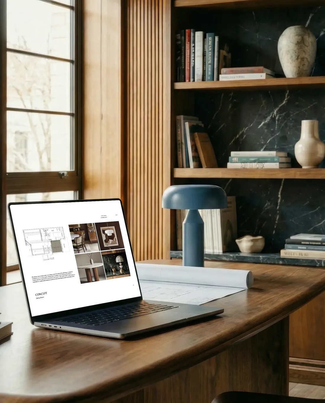 Laptop on a wooden desk with a lamp and books in the background