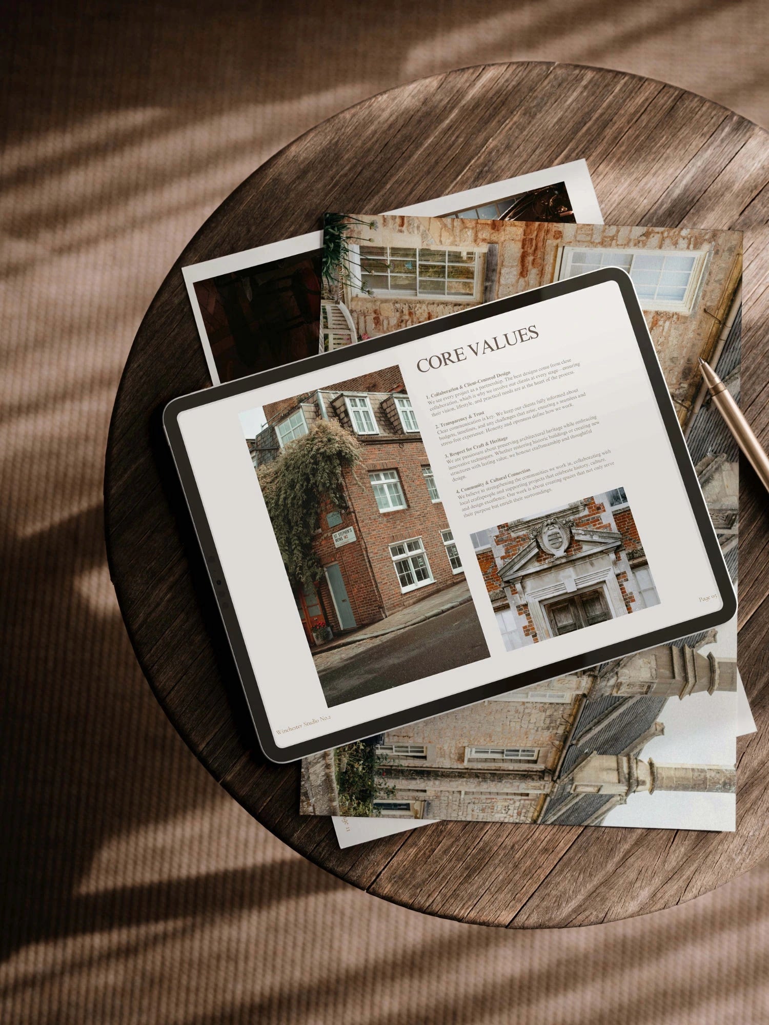 Tablet displaying a document titled 'Core Values' on a wooden table with architectural images.